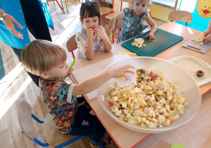 Dzieci wykonują sałatkę owocową, samodzielnie kroją owoce