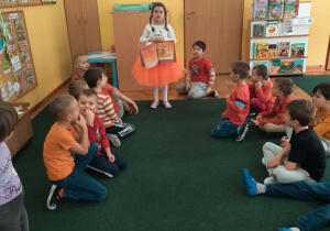 DZeci z grupy elfów czytają wierszyki i rozmawiają o przedmiotach w kolorze pomarańczowym.