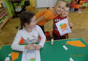 Dzieci z grupy elfów wykonuja pracę plastyczną wyklejankę.