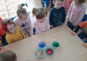 Dzieci z grupy I oglądają eksperyment- barwienie wody bibułą