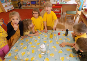 Dzieci wykonują eksperyment z żółtym barwnikiem.