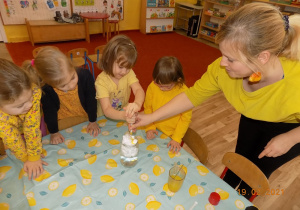 Dzieci wykonują eksperyment z żółtym barwnikiem.