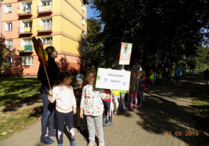 Dzieci trzymają transparenty z hasłami dotyczącymi ochrony środowiska