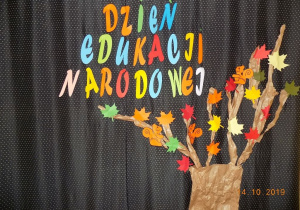Dekoracja na płótnie. Drzewo z jesiennymi liśćmi oraz napis "Dzień Edukacji Narodowej"