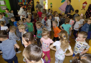 Dzieci i pracownicy przedszkola kańczą na sali gimnastycznej