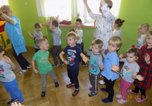 Dzieci wymachują rękami w rytm muzyki