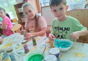 dzieci dekorują ciasteczka wielkanocne