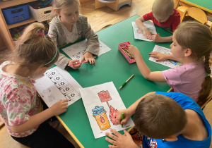 Dzieci kolorują obrazki dotyczące ochrony środowiska