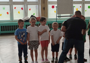 Dzieci stoją do odznaczenia medalem