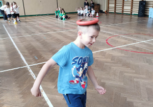 Chłopiec idzie z krążkiem na głowie