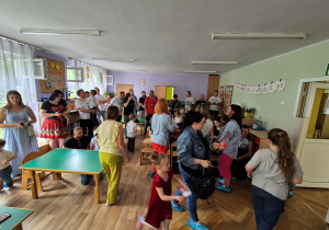 Dzieci podchodzą do rodziców i składają życzenia, wręczają prezenty.