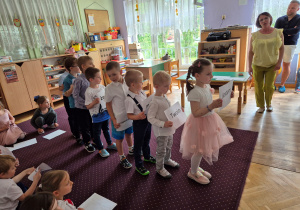 Dzieci idą z kartkami, które tworzą napis dla taty: Jestem twoim małym przypomnieniem, że jesteś: ważny, kochany, silny, odważny, niesamowity, wyjątkowy.