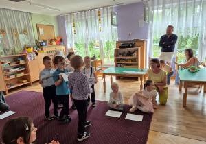 Dzieci idą z kartkami, które tworzą napis dla taty: Jestem twoim małym przypomnieniem, że jesteś: ważny, kochany, silny, odważny, niesamowity, wyjątkowy.