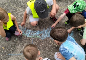 Dzieci rysują kredą statek i morze