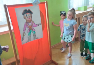 Dzieci oglądają obrazek z piratem przy którym ukryło się ostatnie zadanie