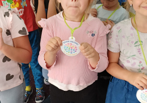 Dziewczynka pokazuje medal z Dnia Kropki.