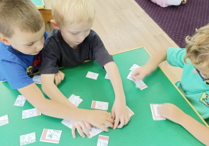 Dzieci układają puzzle z napisem Dzień Przedszkolaka