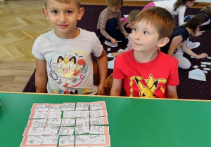 Dzieci układają puzzle z napisem Dzień Przedszkolaka