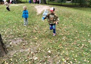 Chłopiec sprząta ogród przedszkolny