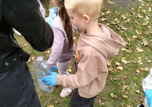 Chłopiec sprząta ogród przedszkolny