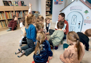 Dzieci słuchają opowiadania czytanego przez panią bibliotekarkę