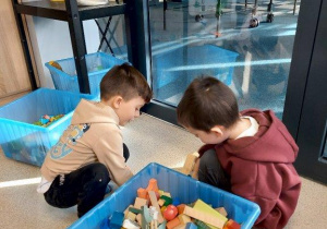 Chłopcy budują z drewnianych klocków