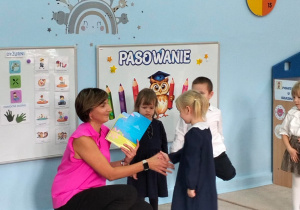 Nauczycielka wręcza dziecku dyplom