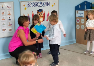 Nauczycielka wręcza dziecku dyplom