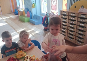 Dzieci wkładają owoce i warzywa do wyciskarki