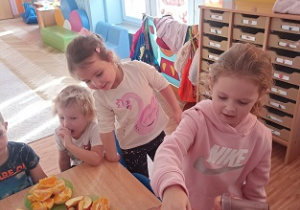 Dzieci wkładają owoce i warzywa do wyciskarki