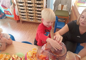 Dzieci wkładają owoce i warzywa do wyciskarki