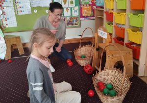 Dziewczynka rzuca kostką do gry.