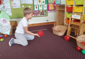 Chłopiec rzuca kostką do gry.