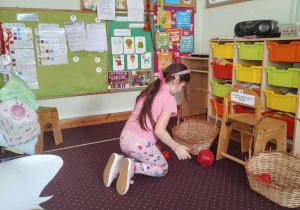 Dziewczynka rzuca kostką do gry.