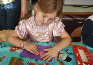 Dziewczynka wykleja z plasteliny swojego bajkostwora.