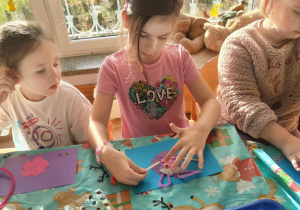 Dzieci wyklejają bajkostwora z plasteliny.