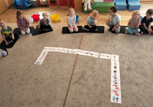 Dzieci układają domino z postaciami z bajek