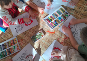 Dzieci kolorują obrazek Czerwonego Kapturka