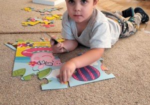 Chłopiec układa puzzle