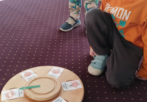 Chłopiec kręci kołem i fortuny i losuje zadanie.