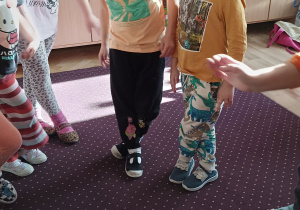 Dzieci wykonują zadanie i krzyżują nogi.