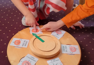 Dzieci losują zadanie na kole fortuny.