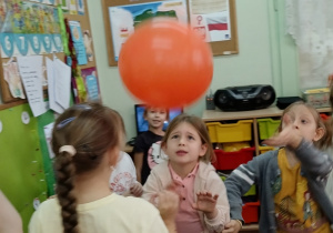 Dzieci odbijają balon.