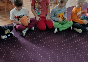 Dzieci podają sobie dynie. Zabawa w dynia goni dynię.