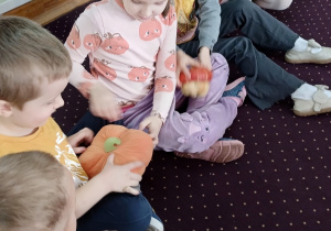 Dzieci podają sobie dynie. Zabawa w dynia goni dynię.