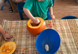 Dziewczynka wydrąża dynie