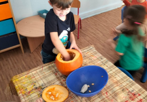 Chłopiec wydrąża dynie