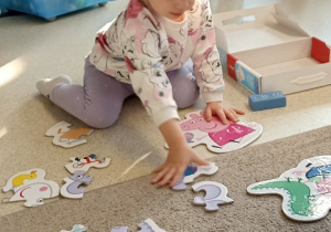 Dziewczynka układa puzzle