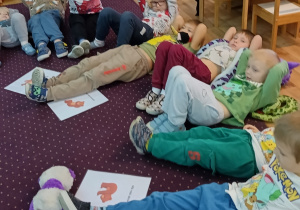 Dzieci wykonują ćwiczenia ruchowe z misiem