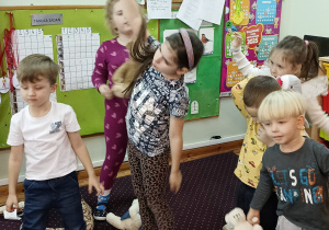 Dzieci wykonują ćwiczenia ruchowe z misiem